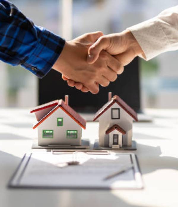 Real estate agents shake hands after the signing of the contract agreement is complete.